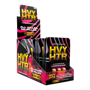 Display box containing packets of HVY HTR pre-workout supplement with black and pink packaging.