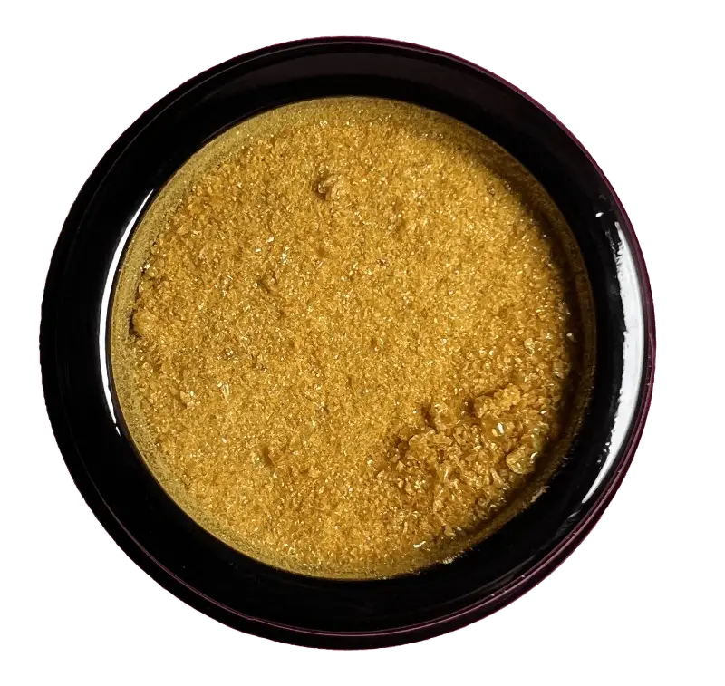 Golden-yellow powder in a dark circular container.