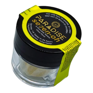 Glass jar with black lid and yellow label containing Paradise Selections cannabis product.